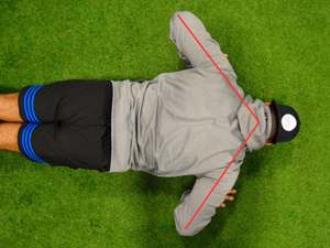 person creating an arrow shape with their arms while doing a push-up