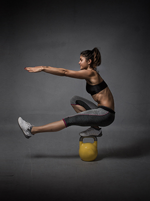 woman balancing in a kettlebell